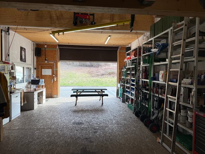 garage space with a picnic table, benches, and metal shelving units with various items