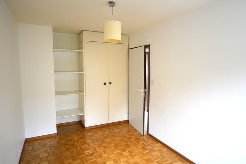 empty room, white walls, wooden floor, double doors, built-in closet with shelves, open door