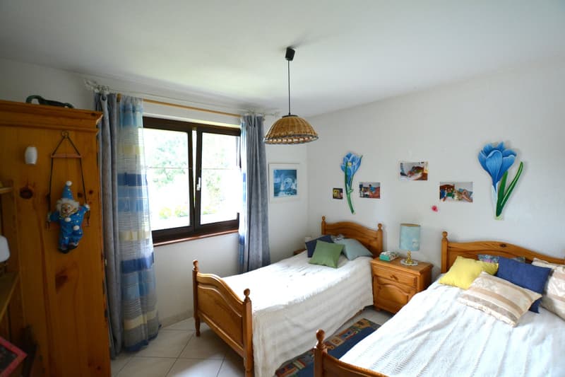 bedroom with two beds, wooden nightstands, wooden closet, view through the window