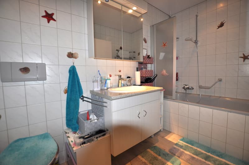 Bathroom with tile flooring, bathtub, shower, sink, mirror, and towel rack