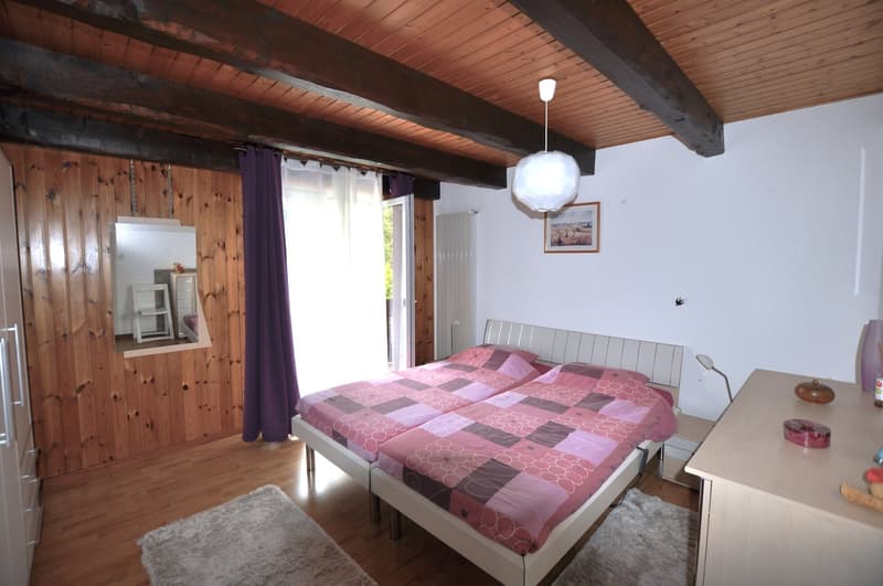 Bedroom with double bed, wooden walls, wooden floor, lamp, nightstands, mirror, curtains, wooden ceiling, wardrobe, two nightstands with lamps