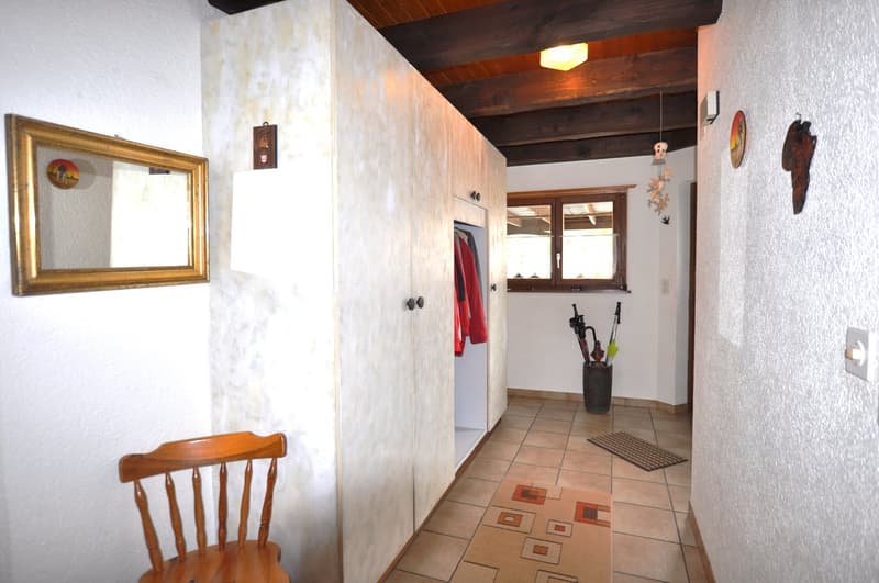 Wooden chair, closet, mirror, tiled floor, window with view to outside