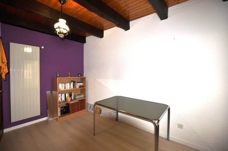 Desk, bookshelf, wooden floor, purple wall, radiator, lamp
