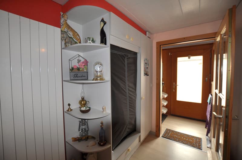 Decorated hallway with shelves, items, and open doors