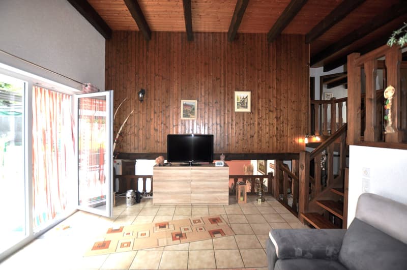 wooden walls, television, wooden cabinet, armchair, decorative rugs, wooden stairs, balcony