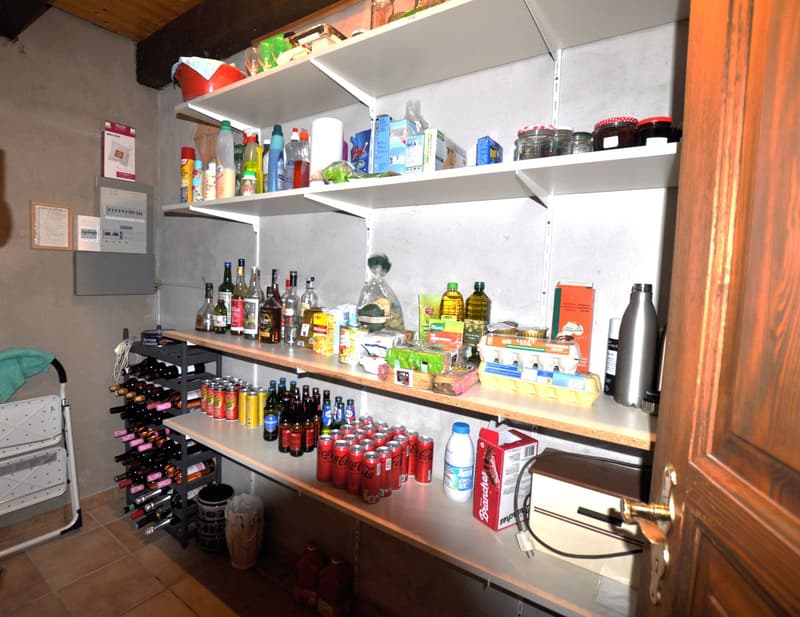 A storage room with shelves, a wooden door, and a rack for wine bottles.