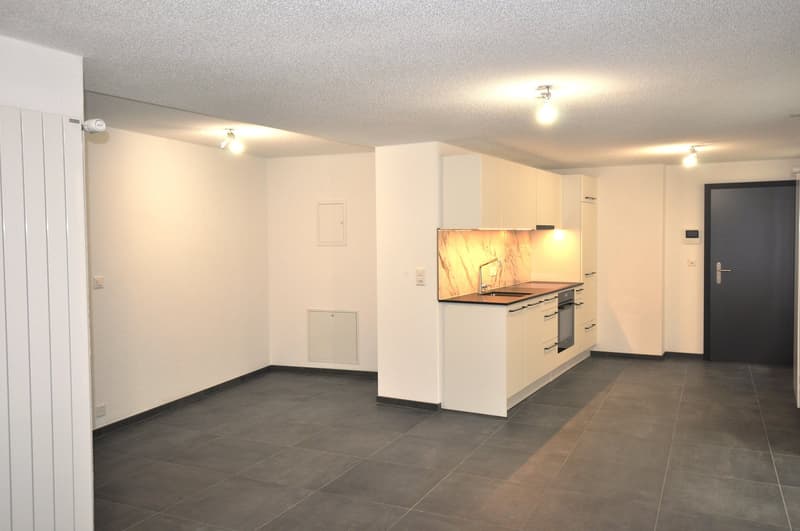 empty kitchen with modern appliances, cabinets, granite countertops, tile flooring, and mounted lights