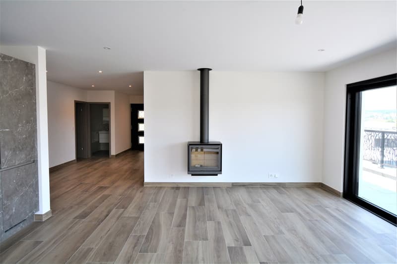 Wooden floor, fireplace, white walls, sliding glass door to balcony