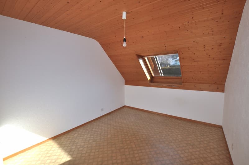 a triangular-shaped room with wooden ceiling, white walls, tiled floor, and a small window with view of outside