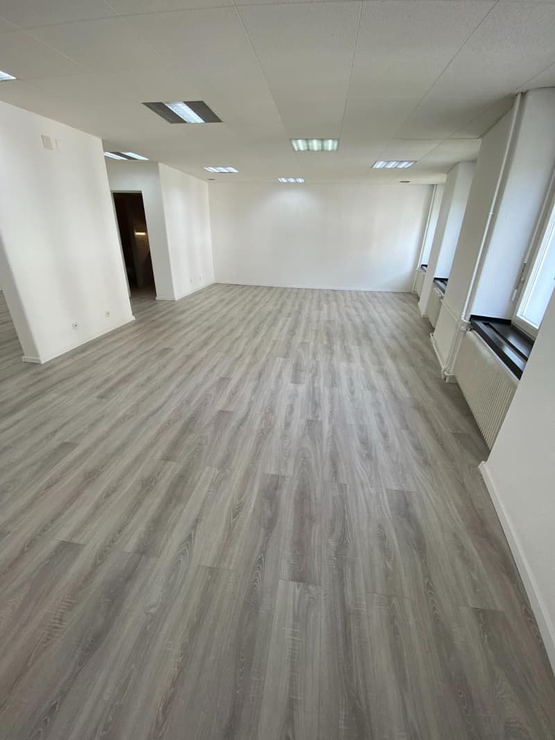 empty room, laminate floor, white walls, recessed ceiling lighting, power outlets