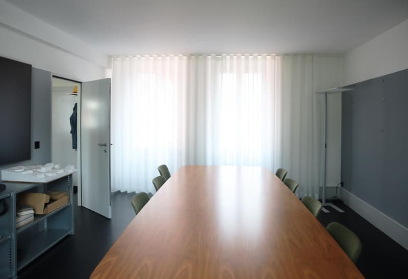 large wooden desk, white curtains, shelves, gray wall