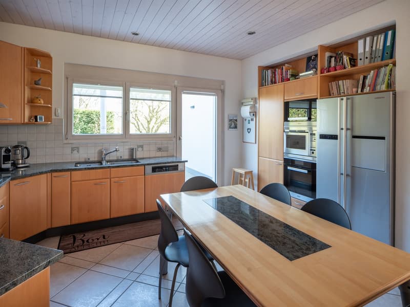 Modern kitchen with wooden cabinets, granite countertops, and stainless steel appliances.