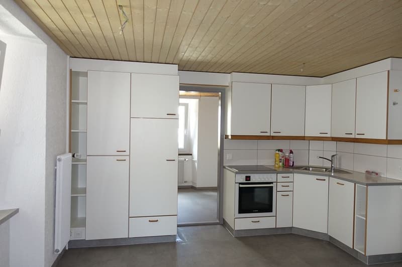 modern kitchen with white cabinets, stainless steel appliances, tiled backsplash, wooden ceiling, and a sink with faucet