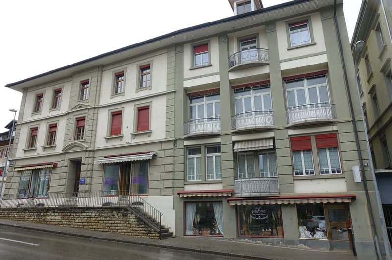 Multiple floor building, balcony, windows with red shutters