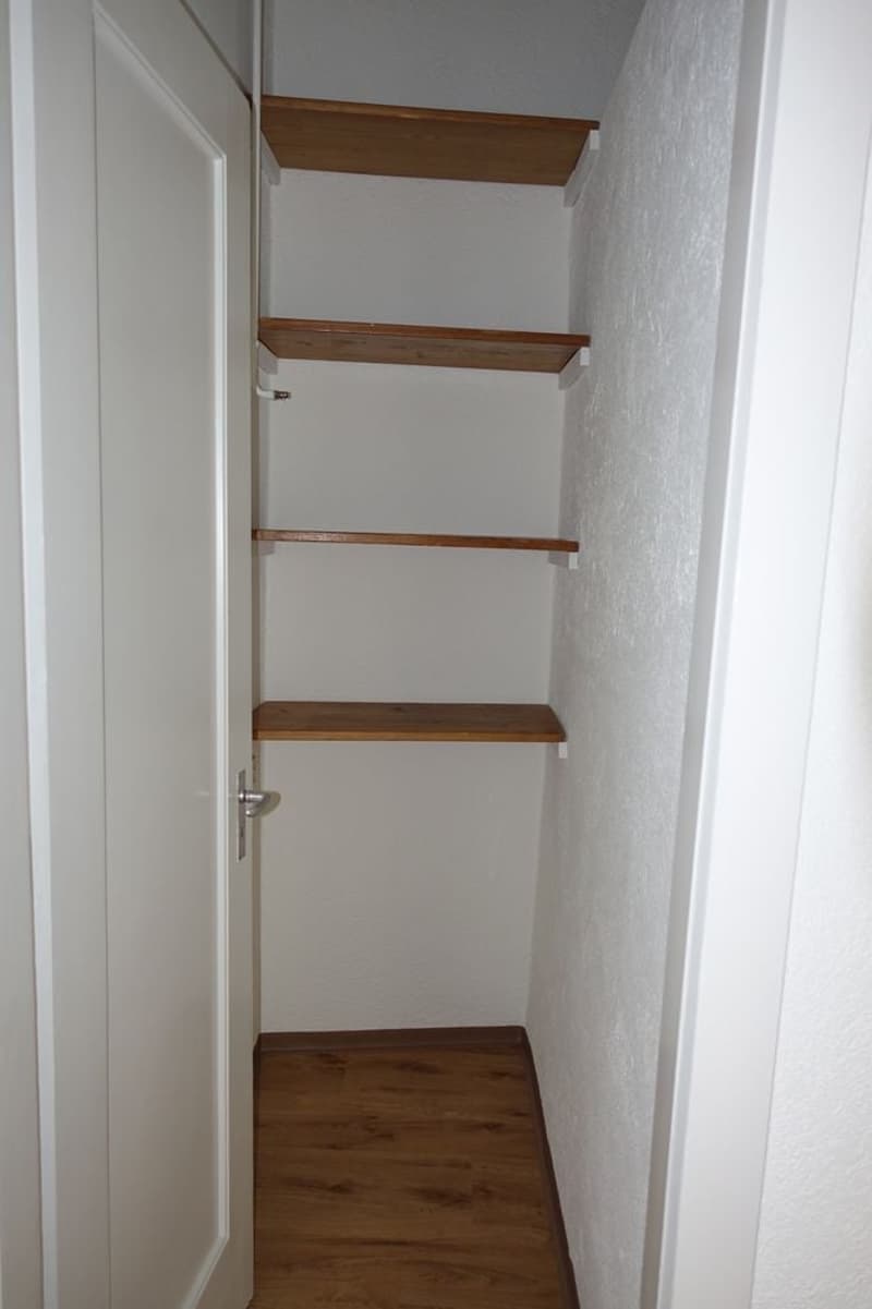 Small room with wooden shelves and wooden floor