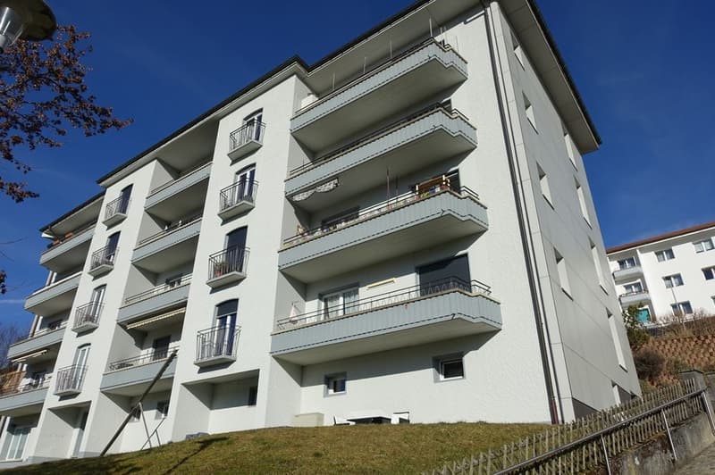 6 story apartment building, multiple balconies, steep hill