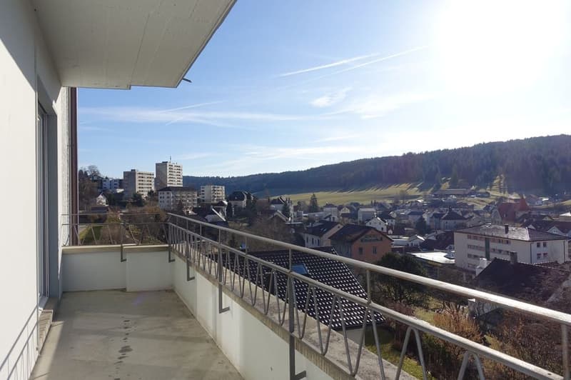 Balcony with metal railings, tiled floor, beautiful view of town and mountains