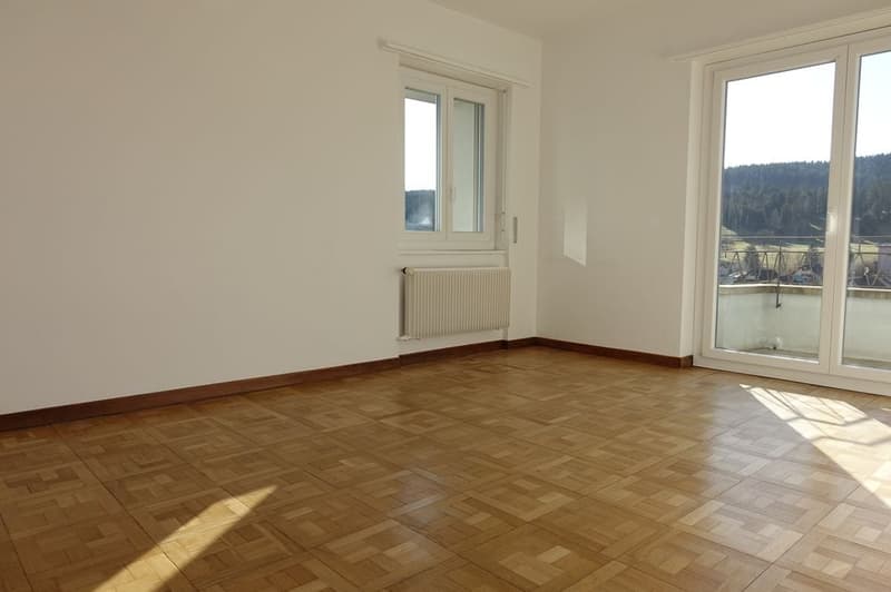 room with white walls, large windows, and hardwood floors, with view to the terrace