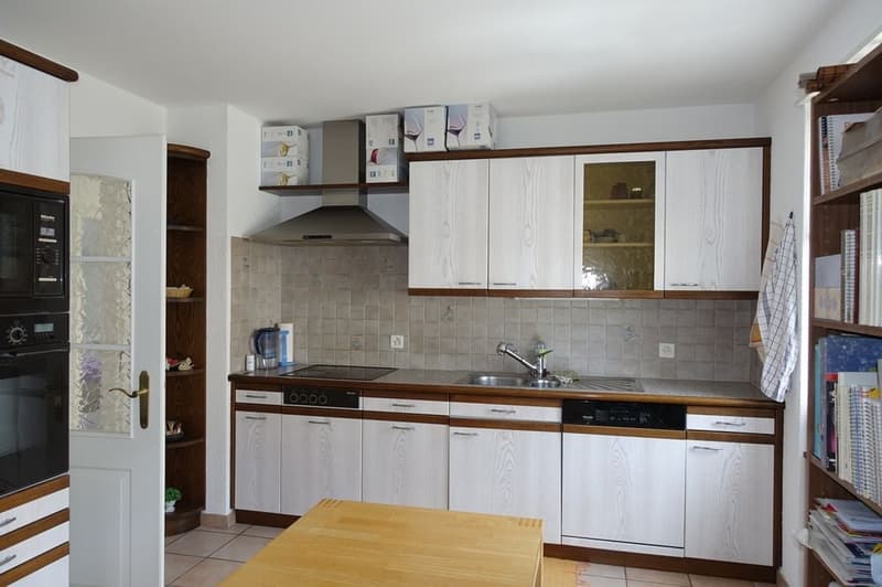 kitchen with tile floor, white wooden cabinets, oven, dishwasher, sink, microwave, wooden table