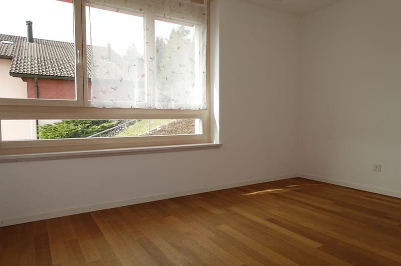 empty room, wooden floor, white walls, large window with curtains, power outlet