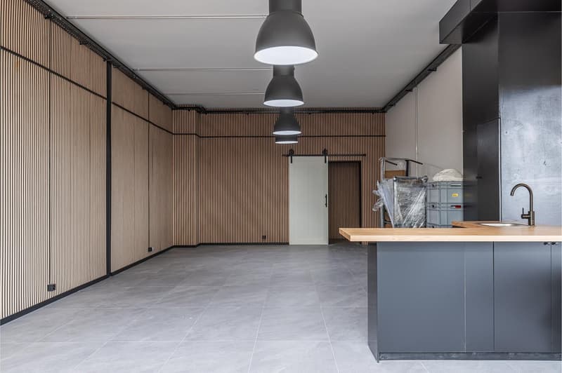 empty room, wooden walls, tiled floor, kitchen area with sink and cabinets