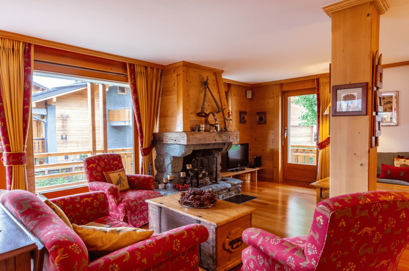 wooden wall, couch, armchair, coffee table, television, fireplace