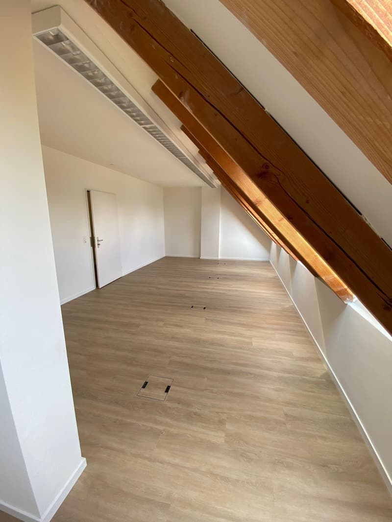 empty room, wooden floor, white walls, sloped ceiling, windows