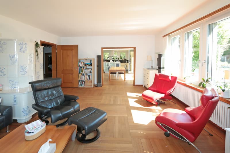 Licht durchfluteter Wohnbereich / a living room with wood floors, black chairs, and a wooden floor