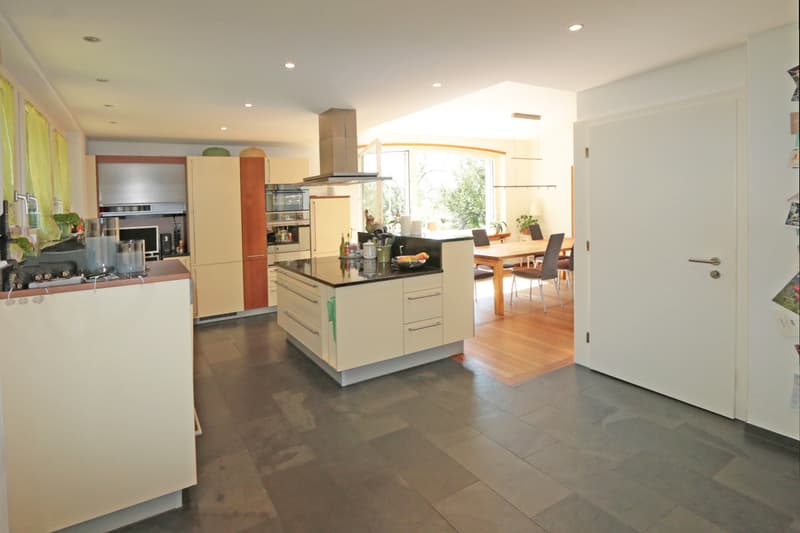 moderne, offene Wohnküche / a modern kitchen with white cabinets and a large sliding door