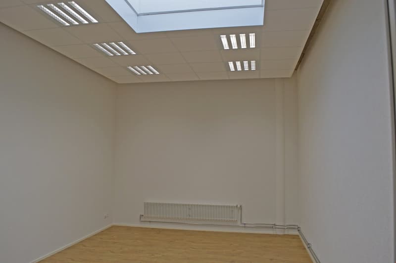 empty room, white walls, wooden floor, white ceiling, white radiator, skylight