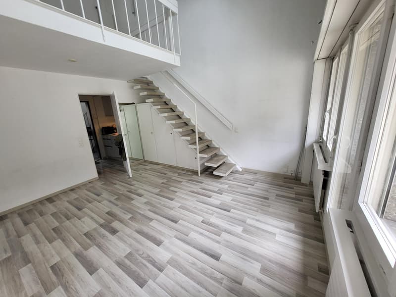 empty room, wooden flooring, white walls, staircase, cabinets, balcony, windows