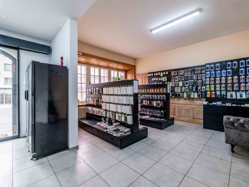 store with white tiles, several shelves with cases, window and door