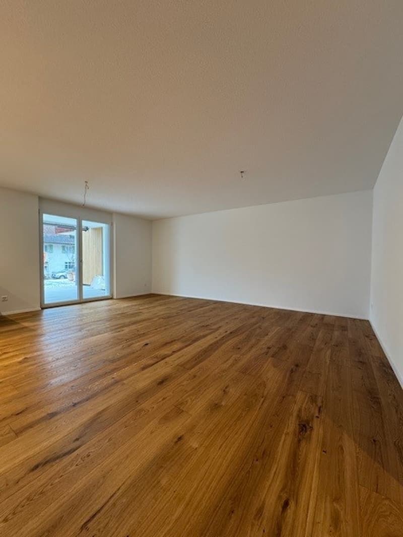 empty room, wooden floor, white walls, sliding glass door with balcony access