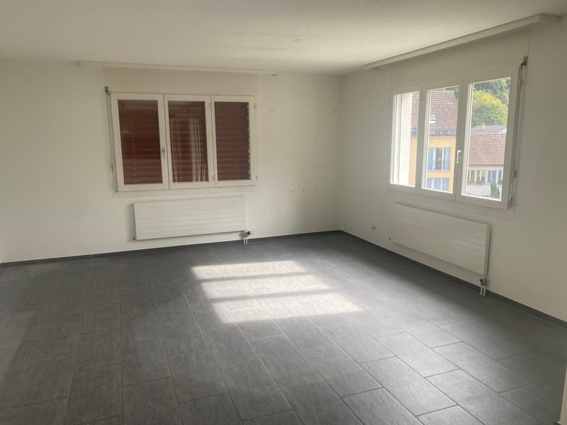 empty room with white walls, two windows, and tiled floor