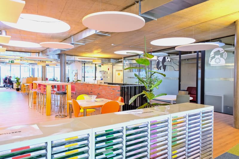 modern interior with large open space, desks, chairs, and a large plant