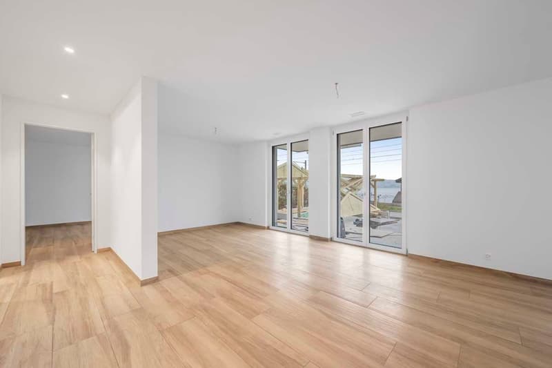empty room, wooden floors, sliding glass doors leading to balcony