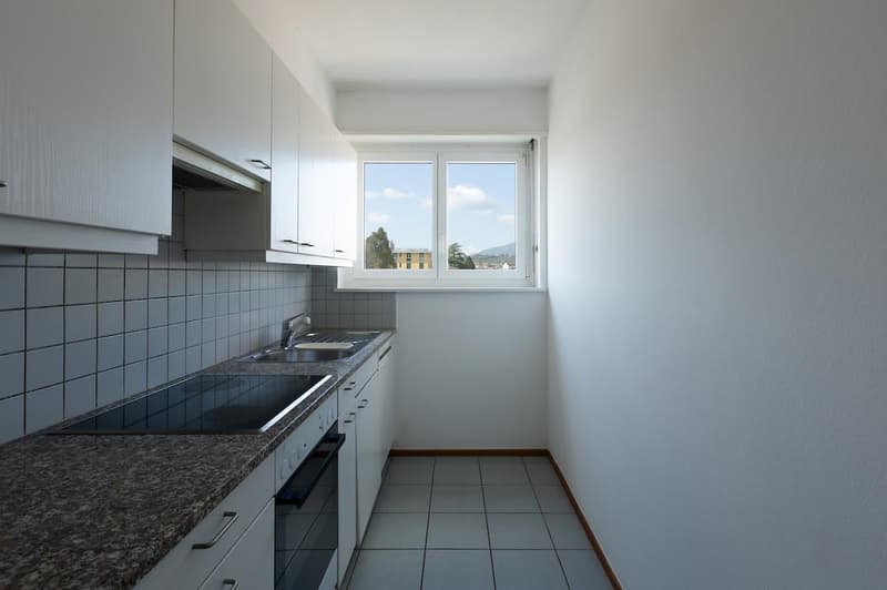 modern white kitchen, granite countertop, integrated appliances, large window, white tiled floor