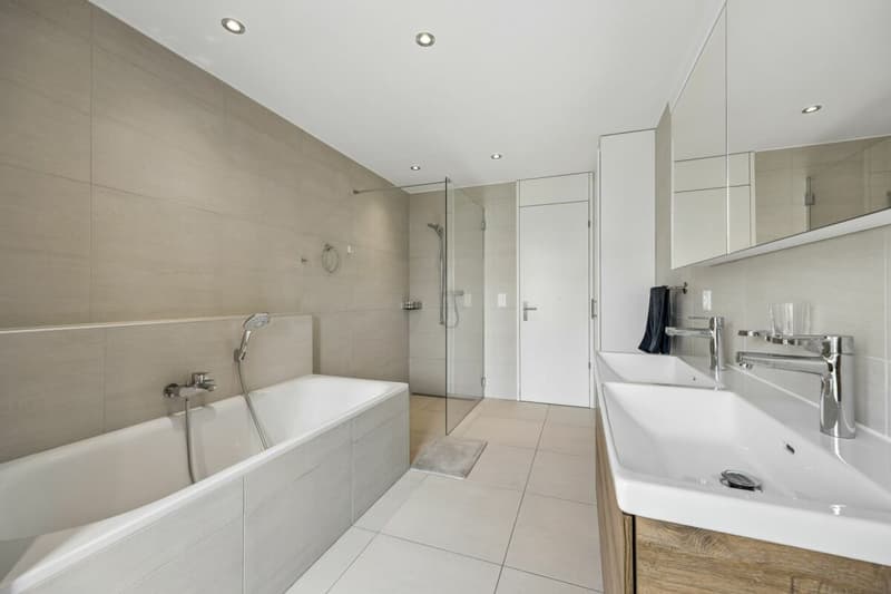 Badezimmer mit Dusche, Badewanne und Doppelwaschbecken