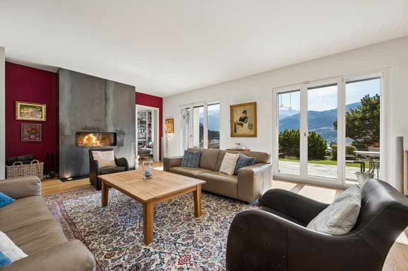 Wohnzimmer mit Cheminée und Zugang zur Terrasse