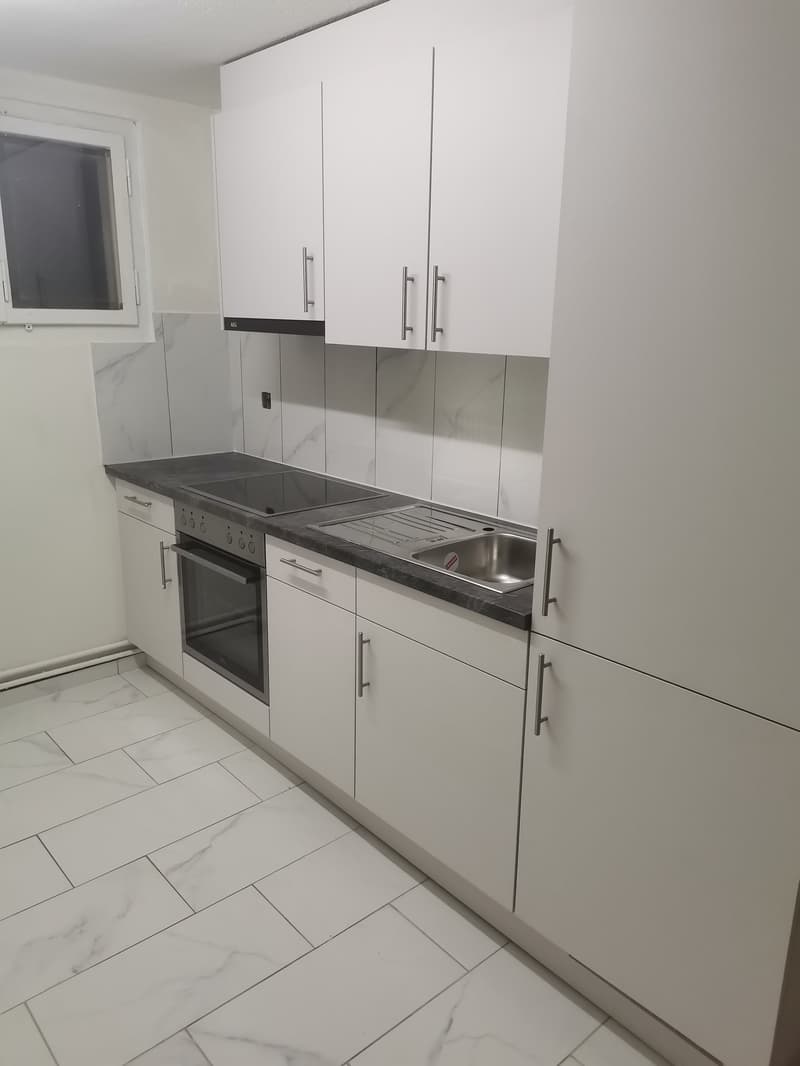 modern kitchen with white marble countertops, large stainless steel sink, dishwasher, oven, marble floor