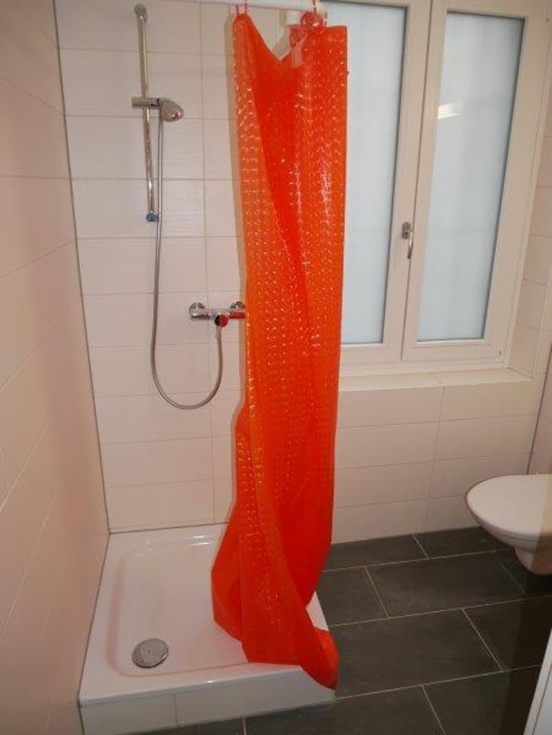Bathroom with a shower curtain in a bright orange color