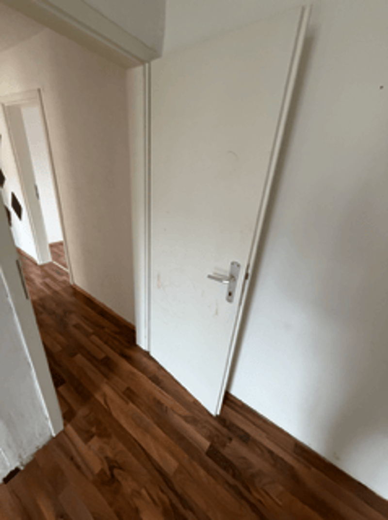 empty room, hardwood floor, white walls, open door leading to another room