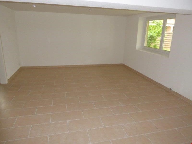 Empty room with white walls, tiled flooring, a single window