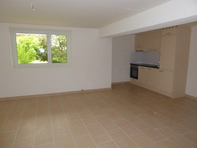 empty room, tile flooring, white walls, large window, kitchen with cabinets and oven
