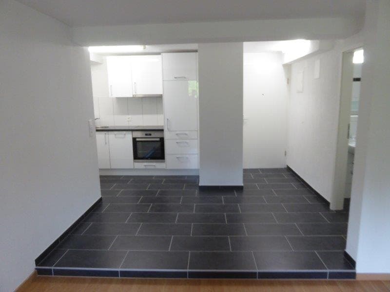empty kitchen with white cabinets, black tiled floor, built-in oven