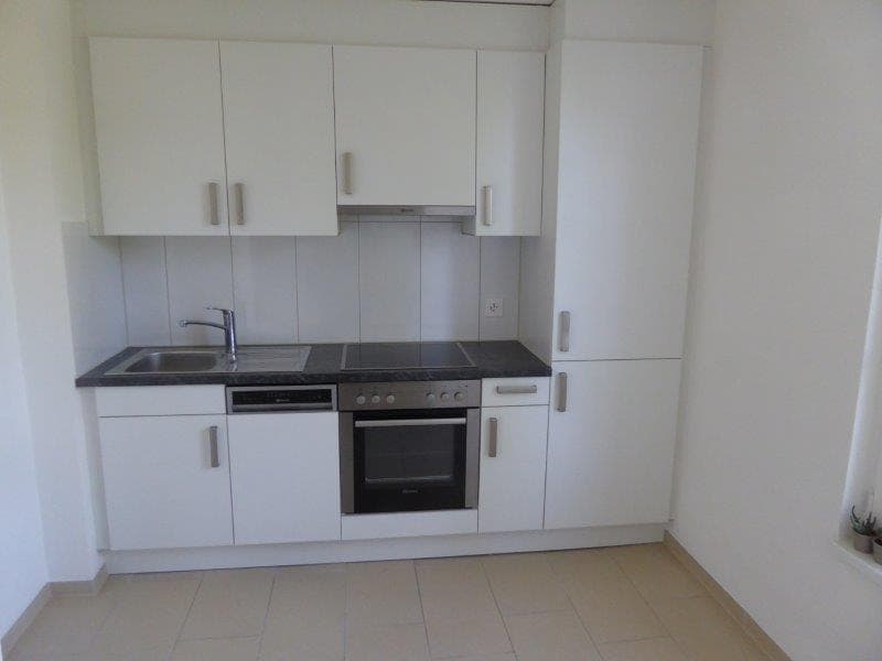 White cabinetry, granite countertop, stainless steel appliances, dishwasher, and sink with faucet