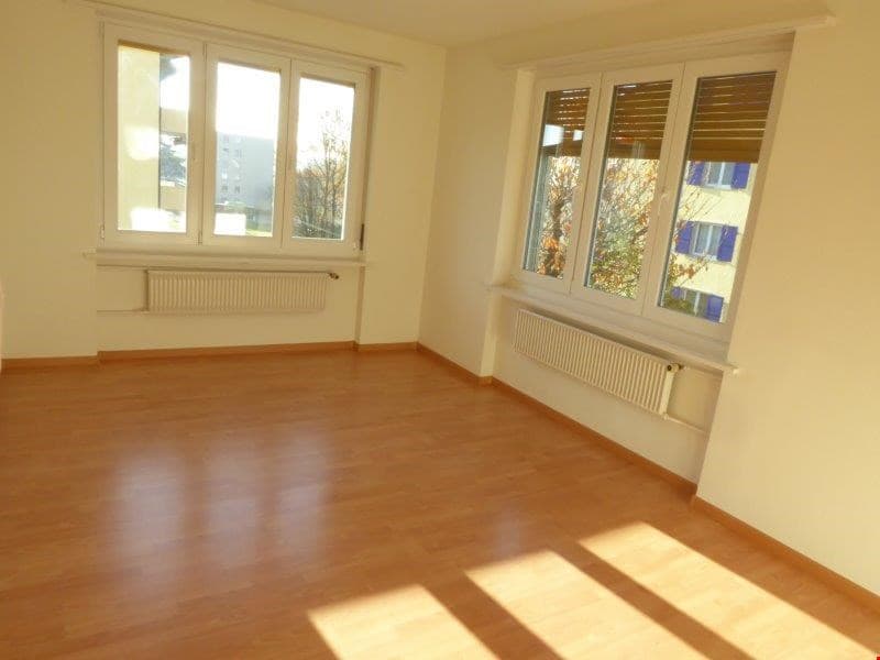 empty room, wooden floor, white walls, two large windows, white radiators