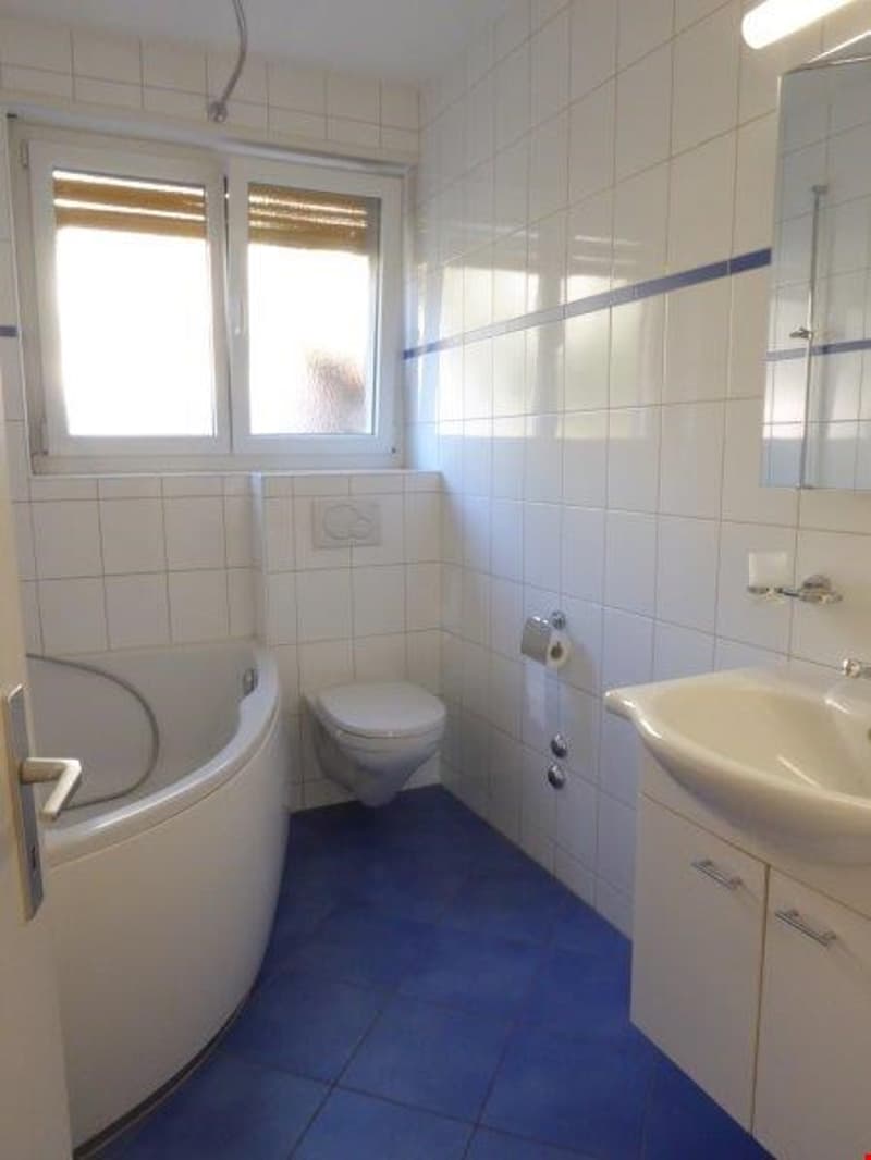 Bathroom with bathtub, toilet, sink, and mirror