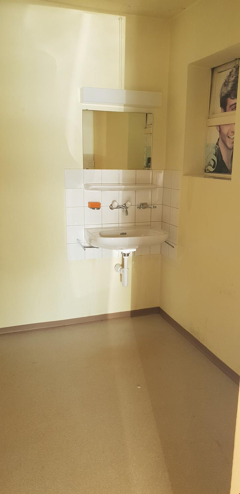 Bathroom with sink, mirror, and power outlet