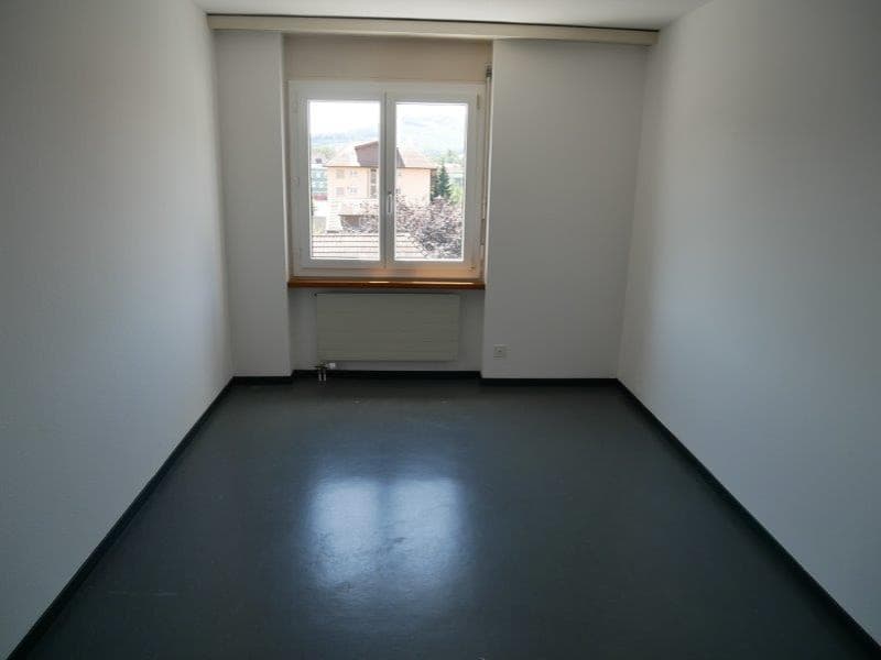 empty room, white walls, black floor, window, radiator